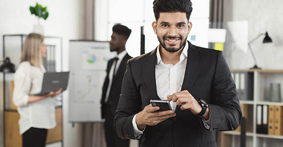 a business professional holding a phone looking towards the camera