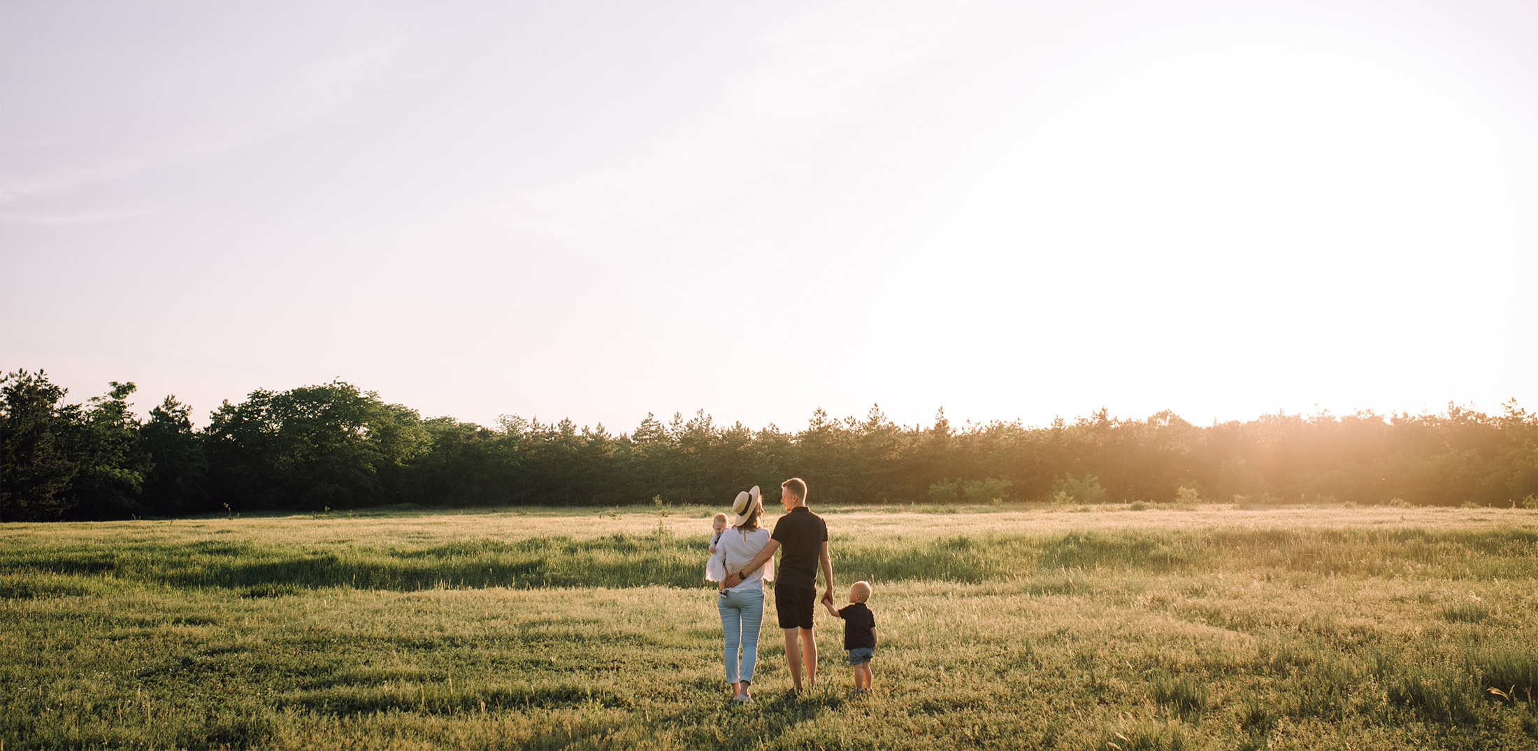 a family standing in a field with the children in their arms