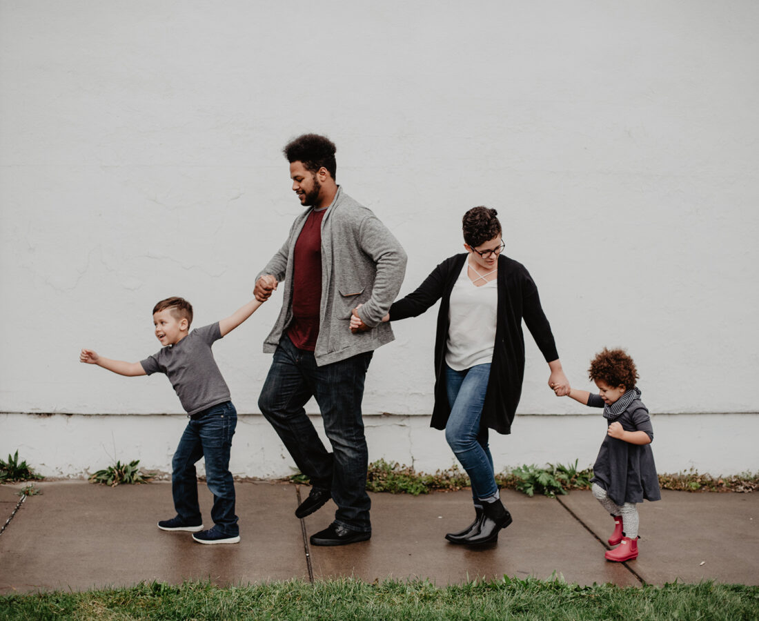 a family walking down the sidewalk with their kids