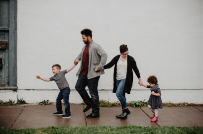 a family walking down the sidewalk with their kids