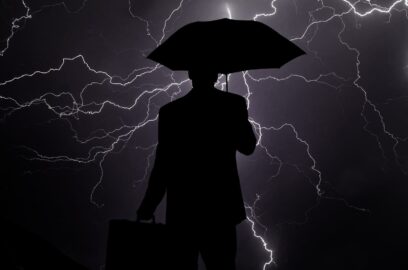 the outline of a man with an umbrella during a lightning storm