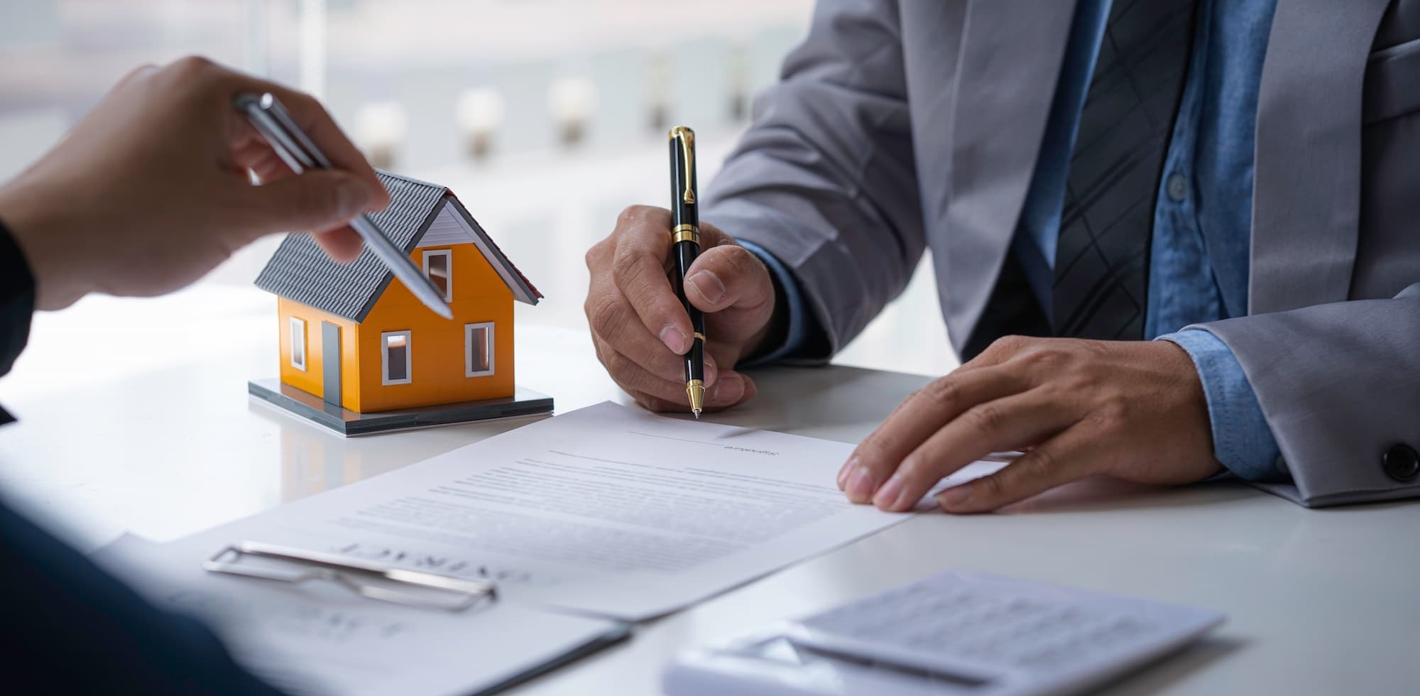 two professionals points pens at a lengthy document