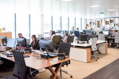 a busy open office space with workers at their desks