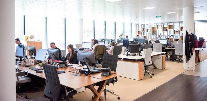 a busy open office space with workers at their desks
