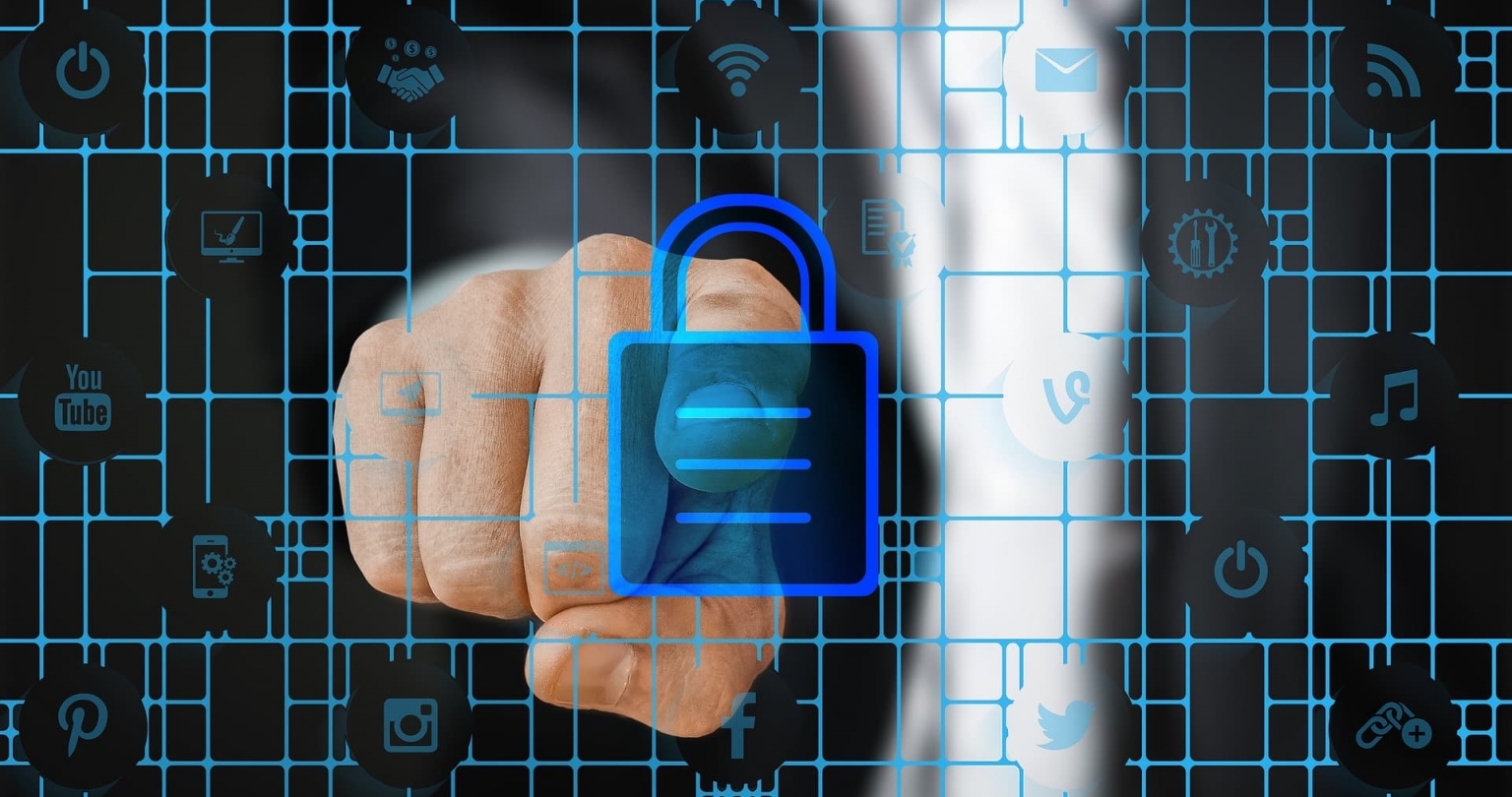 A person pointing to a graphic of a lick in the foreground symbolizing cyber security