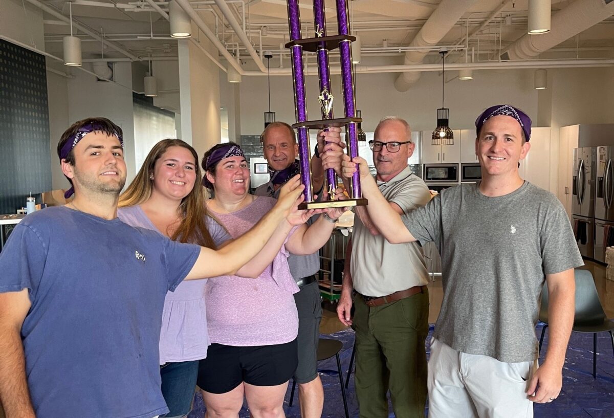 BGM team members holding a trophy