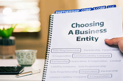 A document on different types of business formations being read by a small business owner while sitting in office desk.