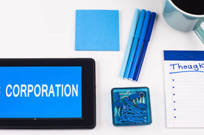 Picture of table with a tablet that has S Corporation text on it with various office supplies to the side.