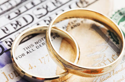 2 wedding rings overlapping each other sitting on top of cash
