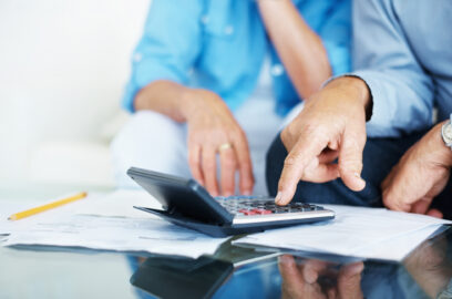 Closeup of a senior man's hand calculating bills at home