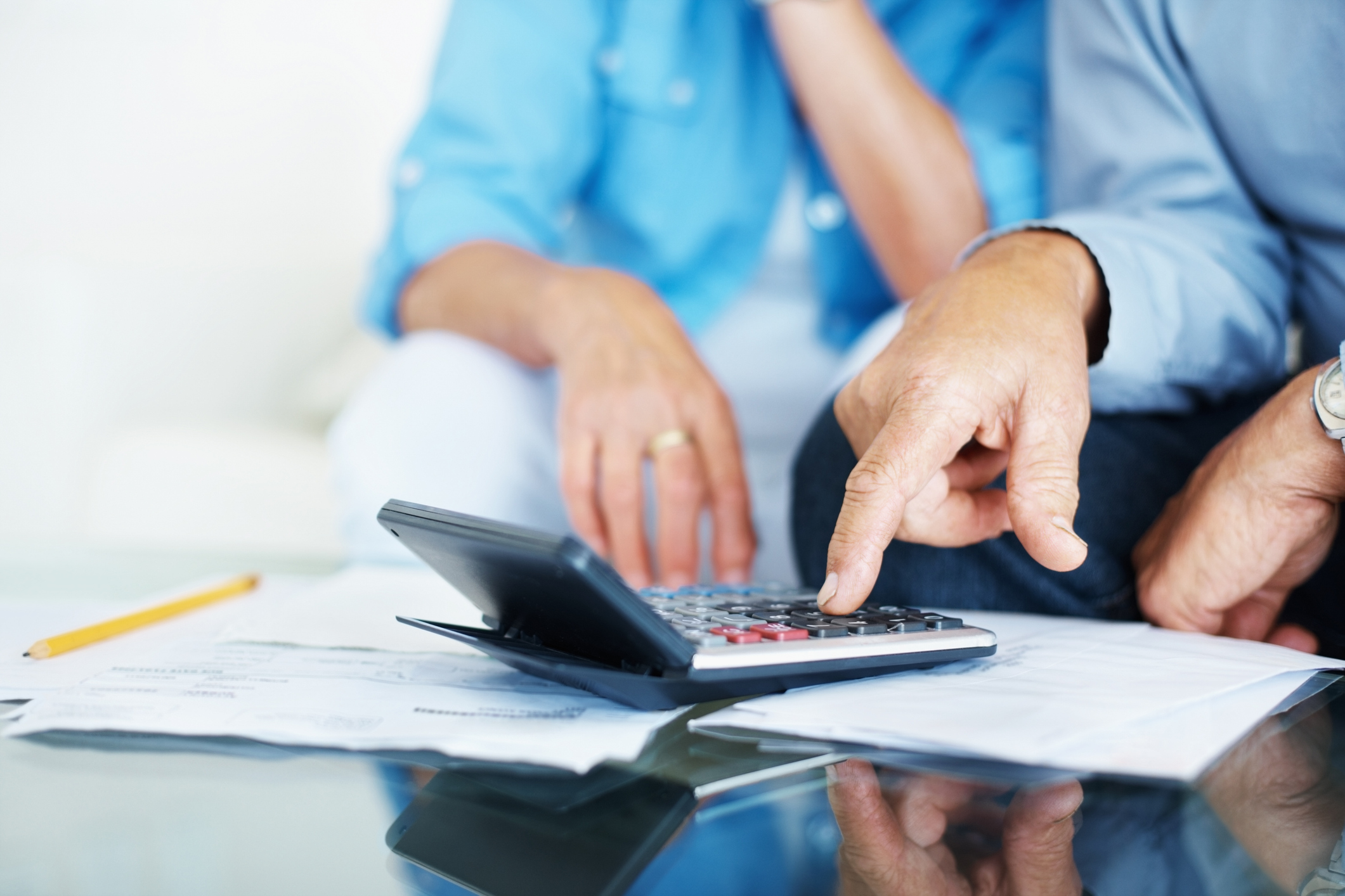 Closeup of a senior man's hand calculating bills at home