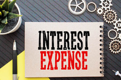 Business concept. Text Interest Expense with banknote, pen and calculator on wooden table background.