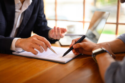 Closeup lawyer pointing at contract showing male client where to signature sign