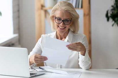 Woman reviewing documents while sitting at a desk.