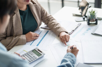People at desk looking at financial documents with calculator