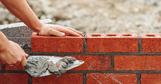 Close-up,Of,Skilled,Bricklayer,Working,On,Construction,Site,Laying,Bricks