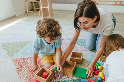 Young,Woman,Teacher,Playing,In,A,Kindergarten,With,Children,On