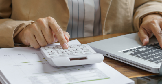 Desk, Laptop, person, clicking, calculator, papers