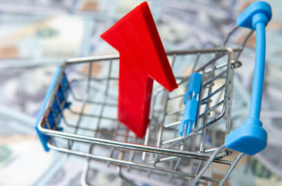 A,Shopping,Cart,And,Red,Upward,Pointing,Arrow,On,A, bed, of, lurred, one, hundred,u.s.,dollar,bills,increasing,costs,consumer,spending,concept