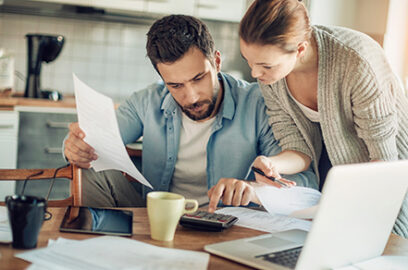 Two people, Male and female, reviewing documents, observing Desk, Laptop, Coffee