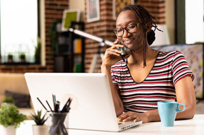 Self,Employed,Woman,Sits,At,Desk,,Multitasking,,Speaks,With,Clients