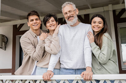 family of four, hugging, outdoors, on patio,