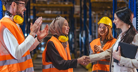 Diverse,Warehouse,Workers,In,High-visibility,Vests,And,Hard,Hats,Shake