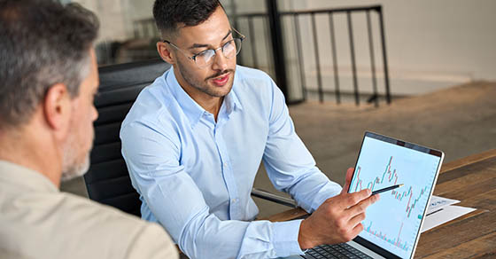 Financial,Advisor,Explaining,Invest,Stock,Market,Data,Consulting,Investor.,Two, busy business men, analysts, doing finance, trading analysis, pointing at exchange chart, on laptop screen, working in office.