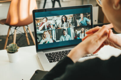 Close up of woman at desk, participating in a video call webinar on her laptop