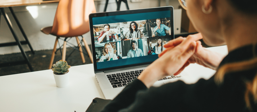 Close up of woman at desk, participating in a video call webinar on her laptop