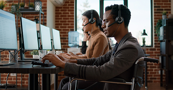 Customer, service, desk, two employees, sitting in front of their computers
