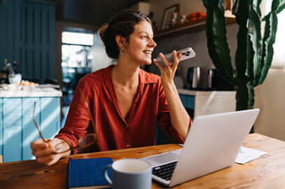 Working, remote, woman, sitting, at, home, desk, laptop, in, front, of her, talking, on the phone