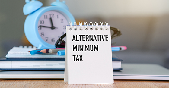 Notepad, textL Alternative Minimum Tax, sitting on desk, clock