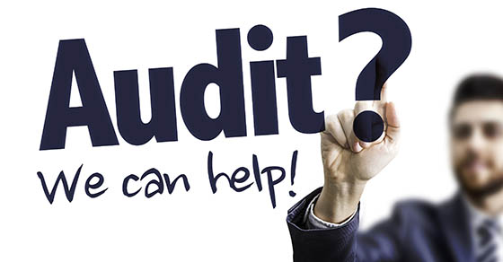 Business professional, writing on white board, text: Audit? We can help!